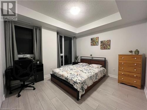 Bedroom with light hardwood / wood-style floors, a raised ceiling, and a textured ceiling - 55 Duke Street W Unit# 1607, Kitchener, ON - Indoor Photo Showing Bedroom