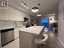 Kitchen with white cabinetry, a center island, sink, pendant lighting, and appliances with stainless steel finishes - 55 Duke Street W Unit# 1607, Kitchener, ON  - Indoor Photo Showing Kitchen With Stainless Steel Kitchen With Double Sink 