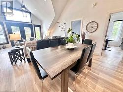 Dining space with high vaulted ceiling and light wood-type flooring - 