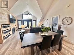 Dining space with high vaulted ceiling and light hardwood / wood-style flooring - 