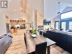 Dining room featuring beamed ceiling, light hardwood / wood-style floors, and high vaulted ceiling - 