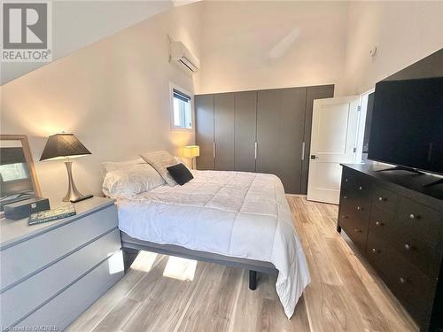 Bedroom featuring light hardwood / wood-style floors, high vaulted ceiling, and a wall mounted AC - 796363 Grey 19 Road, The Blue Mountains, ON - Indoor Photo Showing Bedroom