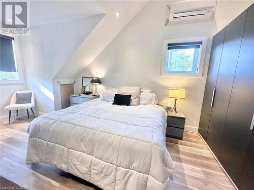 Bedroom with light hardwood / wood-style floors, a wall mounted AC, and lofted ceiling - 796363 Grey 19 Road, The Blue Mountains, ON - Indoor Photo Showing Bedroom