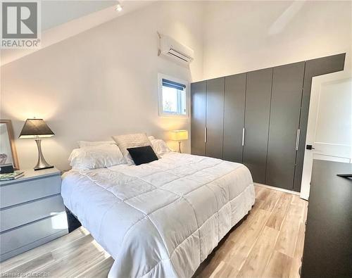 Bedroom featuring a wall unit AC, a closet, vaulted ceiling, and light wood-type flooring - 796363 Grey 19 Road, The Blue Mountains, ON - Indoor Photo Showing Bedroom