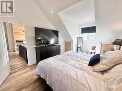 Bedroom featuring light hardwood / wood-style floors and lofted ceiling - 