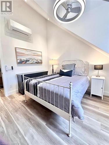 Bedroom featuring ceiling fan, light wood-type flooring, and a wall mounted AC - 796363 Grey 19 Road, The Blue Mountains, ON - Indoor Photo Showing Bedroom