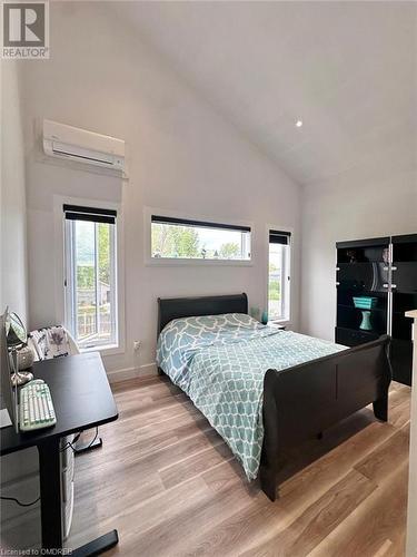 Bedroom featuring multiple windows, light hardwood / wood-style floors, a wall mounted AC, and lofted ceiling - 796363 Grey 19 Road, The Blue Mountains, ON - Indoor Photo Showing Bedroom