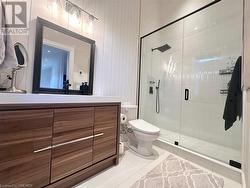 Bathroom with tile patterned flooring, vanity, toilet, and an enclosed shower - 