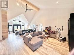 Living room featuring ceiling fan, beam ceiling, light wood-type flooring, and high vaulted ceiling - 