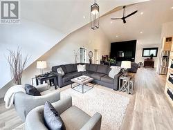 Living room with high vaulted ceiling, light hardwood / wood-style flooring, and ceiling fan - 