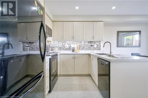 Kitchen with black refrigerator, kitchen peninsula, stainless steel dishwasher, sink, and range - 1145 Riddell Crescent, Hamilton, ON - Indoor Photo Showing Kitchen