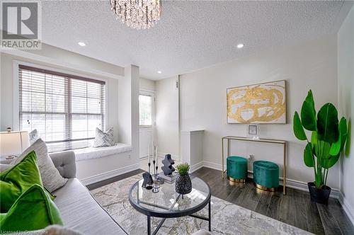 Living room with wood-type flooring and an inviting chandelier - 1145 Riddell Crescent, Hamilton, ON - Indoor Photo Showing Living Room