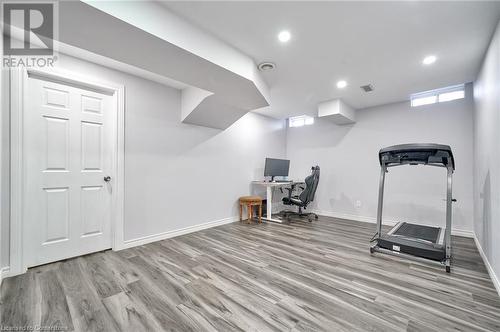 Exercise room featuring a wall mounted air conditioner and wood-type flooring - 1145 Riddell Crescent, Hamilton, ON - Indoor