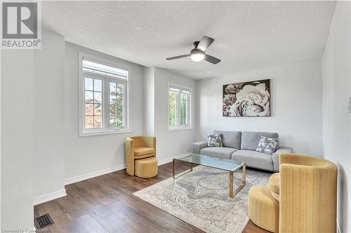 Living room with a textured ceiling, ceiling fan, and dark hardwood / wood-style floors - 48 Isaiah Drive, Kitchener, ON 