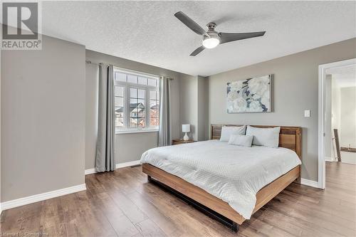 Bedroom with hardwood / wood-style flooring, ceiling fan, and a textured ceiling - 48 Isaiah Drive, Kitchener, ON 