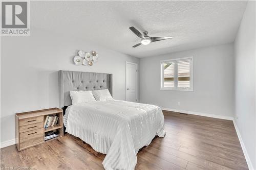 Bedroom featuring ceiling fan, dark hardwood / wood-style flooring, and a textured ceiling - 48 Isaiah Drive, Kitchener, ON 