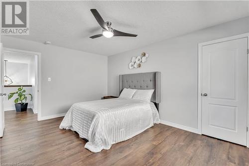 Bedroom with ceiling fan, dark hardwood / wood-style flooring, and a textured ceiling - 48 Isaiah Drive, Kitchener, ON 