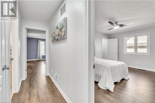 Corridor featuring dark hardwood / wood-style floors and a textured ceiling - 48 Isaiah Drive, Kitchener, ON 