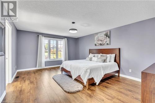 Bedroom with wood-type flooring and a textured ceiling - 48 Isaiah Drive, Kitchener, ON 