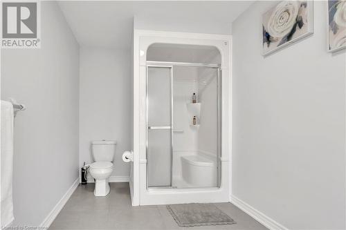 Bathroom featuring tile patterned floors, toilet, and a shower with shower door - 48 Isaiah Drive, Kitchener, ON 