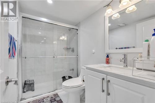 Bathroom with tile patterned flooring, vanity, an enclosed shower, and toilet - 48 Isaiah Drive, Kitchener, ON 