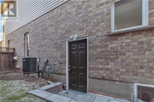 View of exterior entry featuring cooling unit - 48 Isaiah Drive, Kitchener, ON 