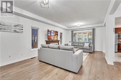 Living room featuring a textured ceiling and light hardwood / wood-style floors - 48 Isaiah Drive, Kitchener, ON 