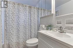 Bathroom with vanity, toilet, tile walls, and walk in shower - 