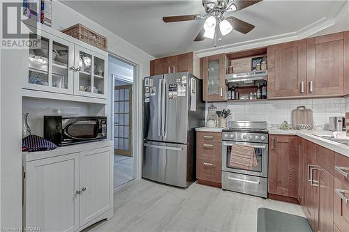 Kitchen featuring tasteful backsplash, ventilation hood, stainless steel appliances, ceiling fan, and light hardwood / wood-style flooring - 476 Prospect Street, Kitchener, ON 