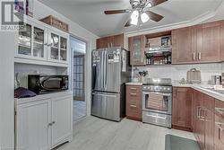 Kitchen featuring tasteful backsplash, ventilation hood, stainless steel appliances, ceiling fan, and light hardwood / wood-style flooring - 