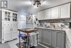 Kitchen featuring white cabinetry and sink - 