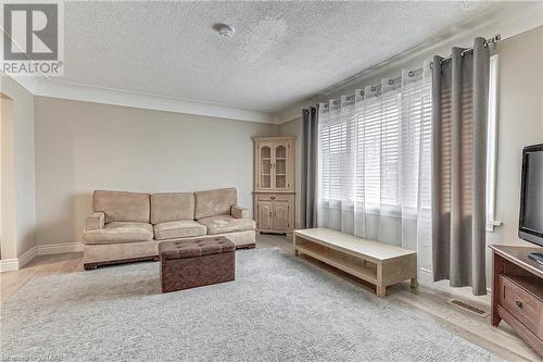 Living room featuring light hardwood / wood-style flooring and a textured ceiling - 476 Prospect Street, Kitchener, ON 