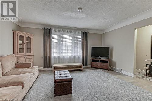 Living room featuring a textured ceiling and light hardwood / wood-style floors - 476 Prospect Street, Kitchener, ON 