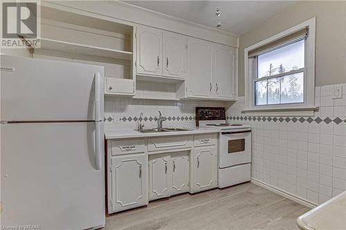 Kitchen featuring white cabinets, electric range oven, white fridge, and light hardwood / wood-style flooring - 476 Prospect Street, Kitchener, ON 