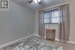 Empty room featuring wood-type flooring and ceiling fan - 