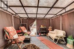 Sitting room featuring wooden walls, carpet, and vaulted ceiling - 