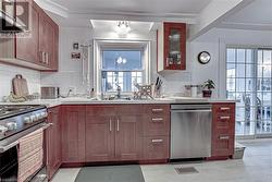 Kitchen featuring decorative backsplash, sink, and appliances with stainless steel finishes - 