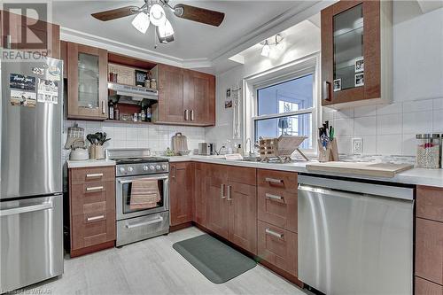 Kitchen featuring ceiling fan, tasteful backsplash, crown molding, exhaust hood, and appliances with stainless steel finishes - 476 Prospect Street, Kitchener, ON 