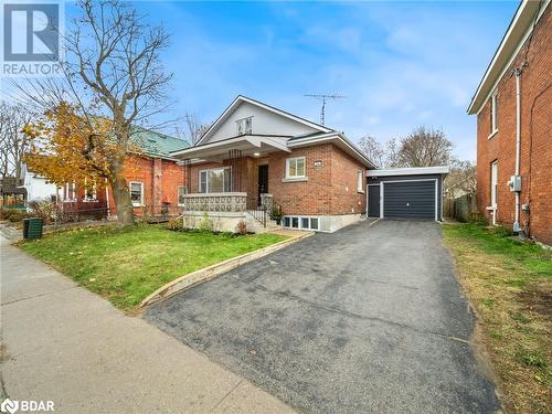 View of front of house featuring an outdoor structure, a porch, a front yard, and a garage - 206 Mary Street, Orillia, ON 