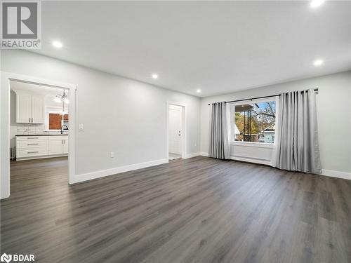 Unfurnished living room with dark hardwood / wood-style flooring, a baseboard radiator, and sink - 206 Mary Street, Orillia, ON 