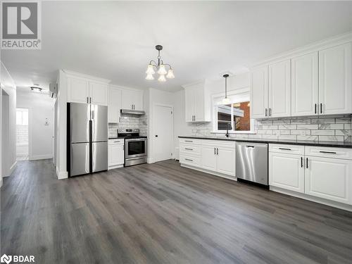 Kitchen featuring a healthy amount of sunlight, white cabinetry, pendant lighting, and appliances with stainless steel finishes - 206 Mary Street, Orillia, ON 