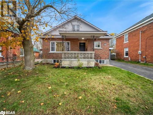 Bungalow-style home featuring central AC unit, a porch, and a front lawn - 206 Mary Street, Orillia, ON 