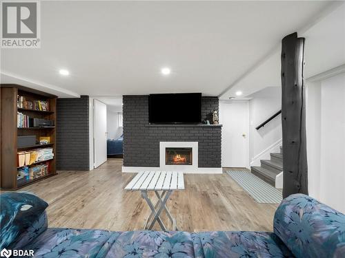 Living room with wood-type flooring and a fireplace - 206 Mary Street, Orillia, ON 