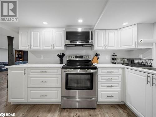 Kitchen featuring white cabinets, stainless steel appliances, and light hardwood / wood-style floors - 206 Mary Street, Orillia, ON 