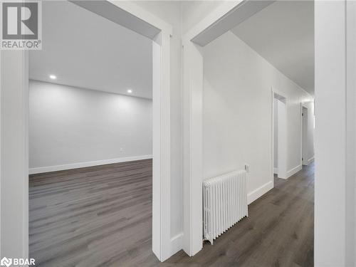 Hallway featuring dark hardwood / wood-style flooring and radiator - 206 Mary Street, Orillia, ON 