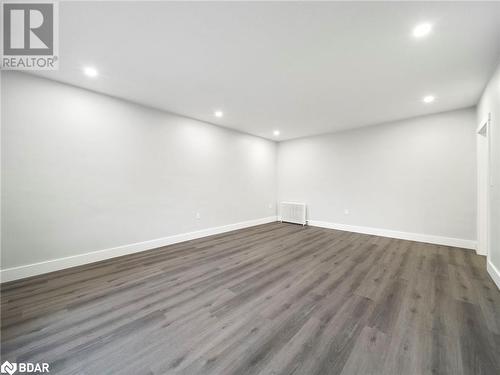 Empty room featuring radiator heating unit and dark hardwood / wood-style floors - 206 Mary Street, Orillia, ON 