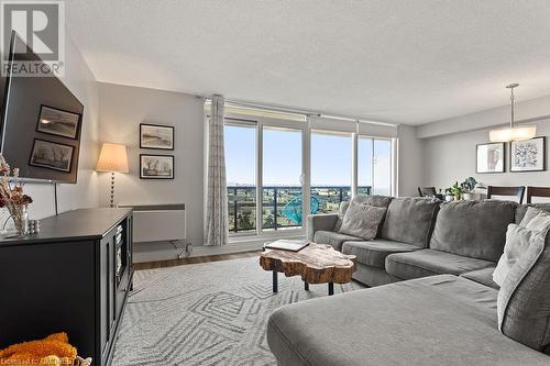 Living room featuring hardwood / wood-style floors and a textured ceiling - 9 Bonheur Court Unit# 802, Brantford, ON 