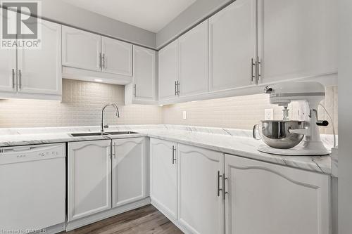 Kitchen featuring dishwasher, white cabinets, and sink - 9 Bonheur Court Unit# 802, Brantford, ON 