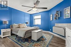 Bedroom with ceiling fan, dark wood-type flooring, and a textured ceiling - 