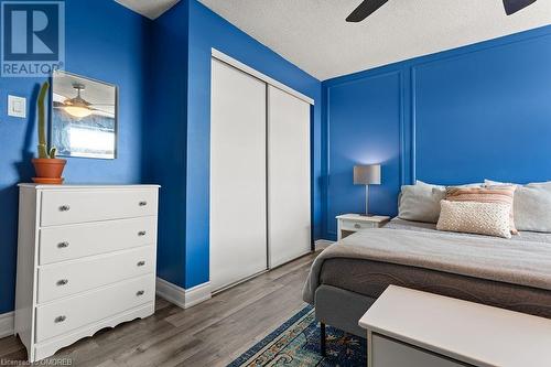 Bedroom featuring ceiling fan, wood-type flooring, a textured ceiling, and a closet - 9 Bonheur Court Unit# 802, Brantford, ON 